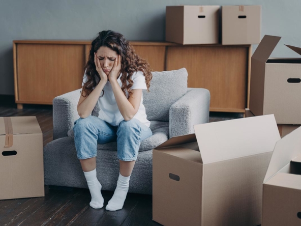 Mujer preocupada rodeada de cajas